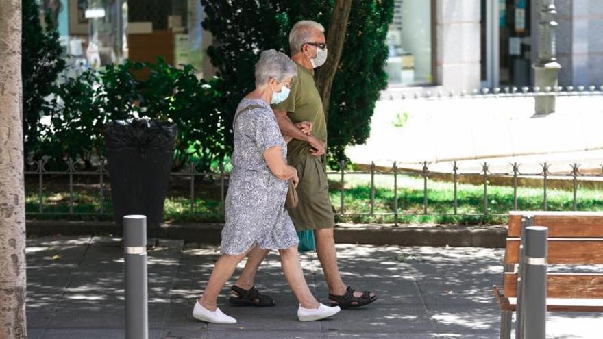 Una pareja de ancianos camina por la calle. | XXXX