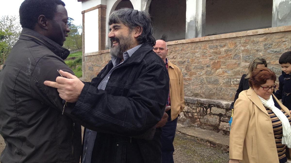 Eustaquio Sánchez (derecha) saludando a feligreses, en una imagen de archivo en su etapa de párroco de San Román de Candamo