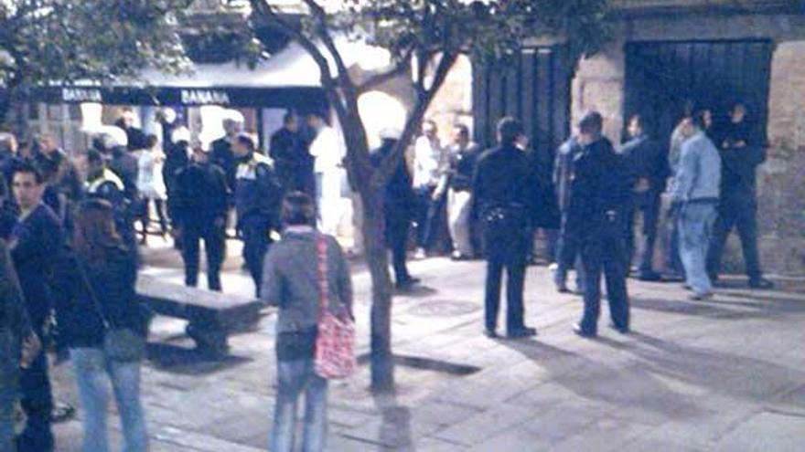 Efectivos de la Policía desalojan a los soldados del local con varios de ellos contra la pared, a la derecha, para ser registrados.