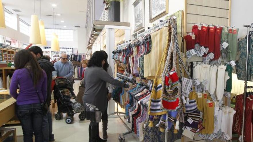 Clientas de la tienda Albaes de Valencia miran los chalecos para el traje de fallero.