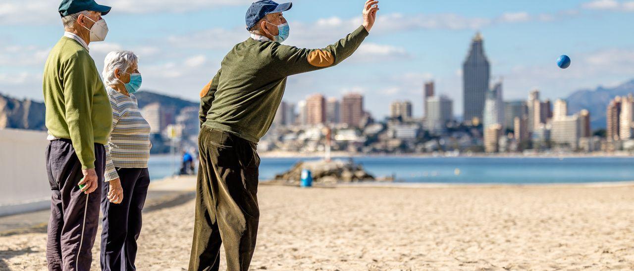 Varios turistas de la tercera edad juegan a la petanca en la playa de Benidorm, el pasado invierno.