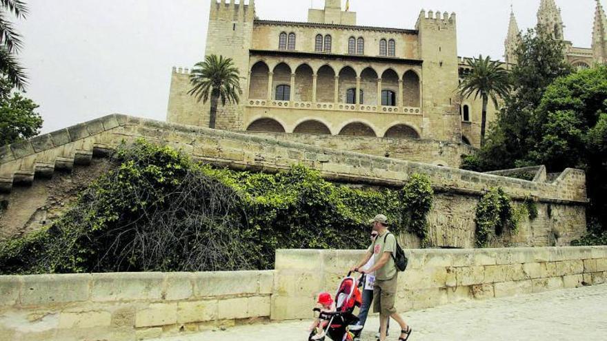 Dos turistas pasean junto al Palacio de la Almudaina.