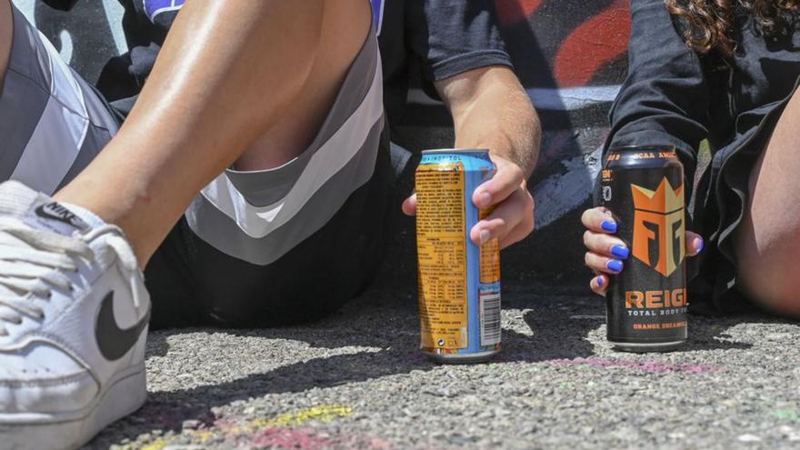 Dos jóvenes, con latas de bebidas energéticas. | Jordi Cotrina