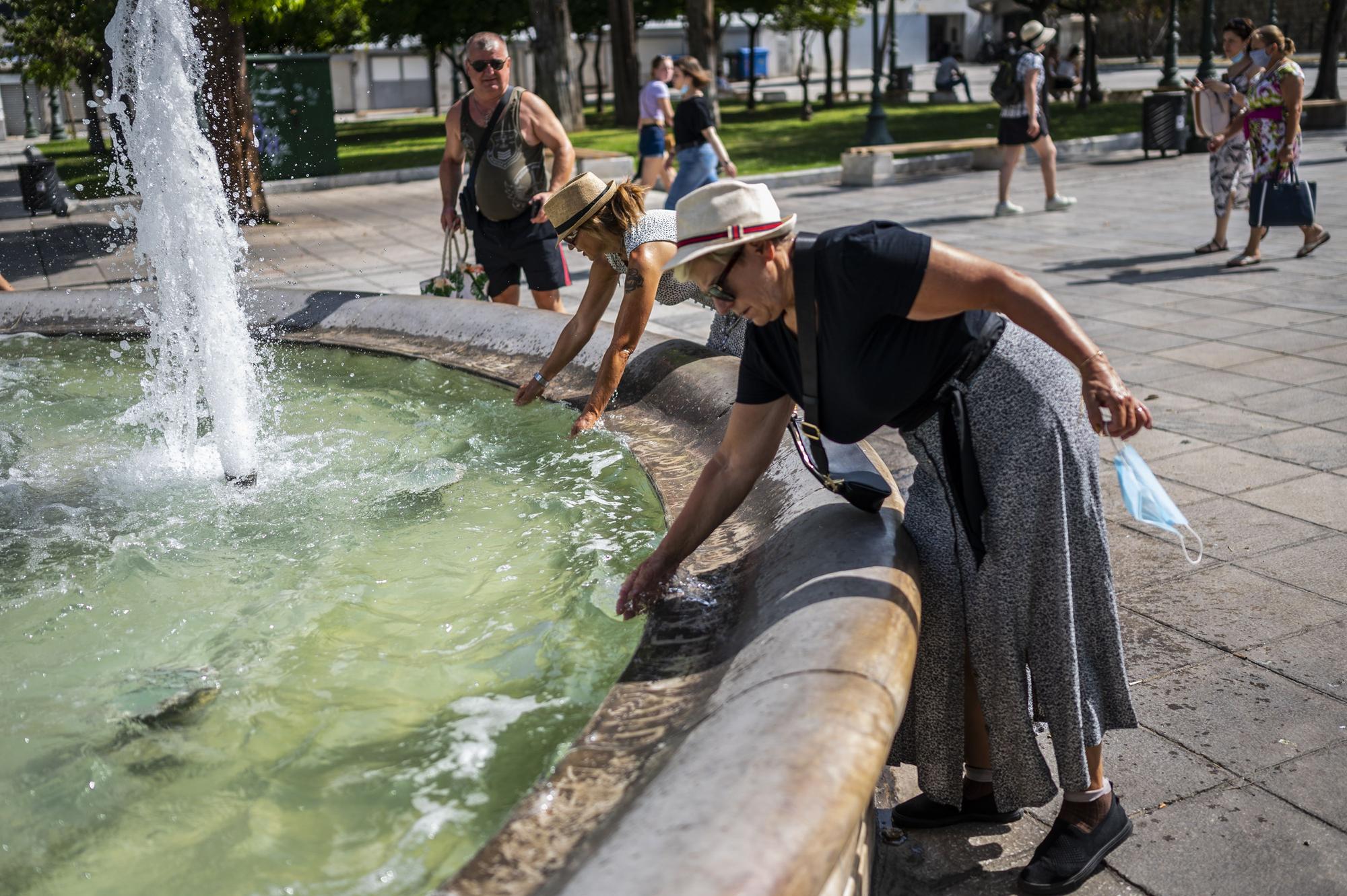 Unas mujeres se refrescan en la fuente de Syntagma Square en plena ola de calor en Grecia.