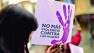 Una mujer sostiene una pancarta contra la violencia contra las mujeres en una manifestación .
