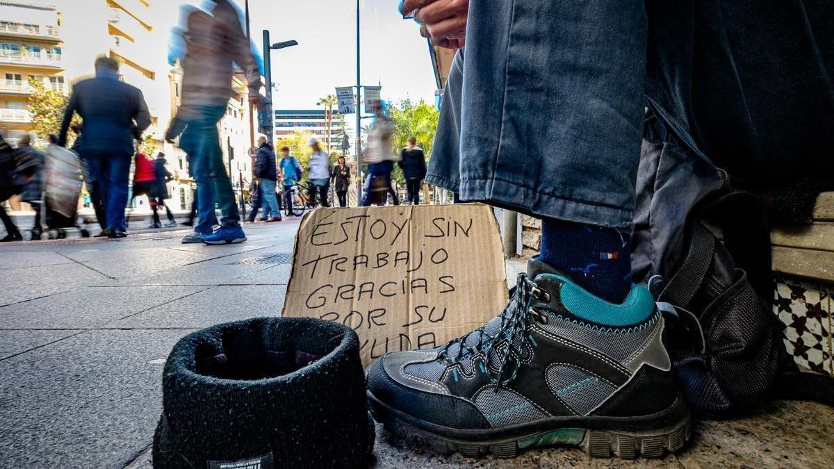 Una persona en riesgo de exclusión social pide ayuda en una calle de la ciudad de Alicante