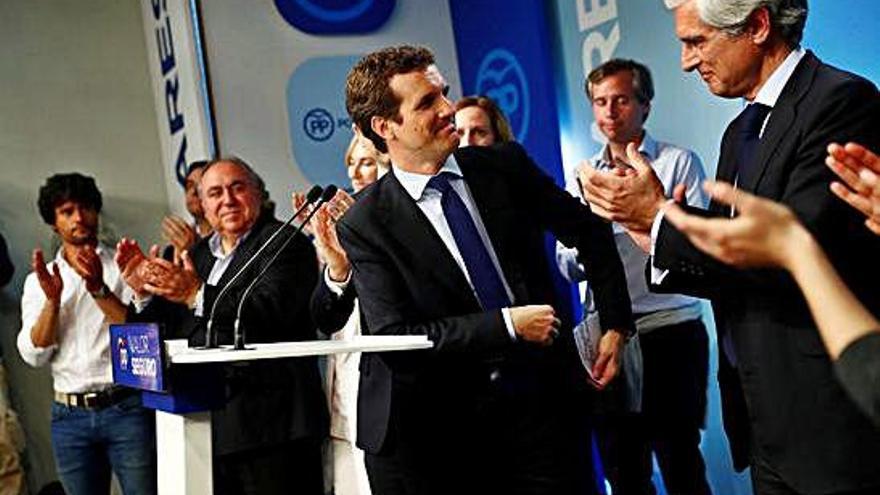 Pablo Casado recibe los aplausos de sus compañeros del PP tras comparecer en Génova; a su izquierda, Adolfo Suárez Illana.