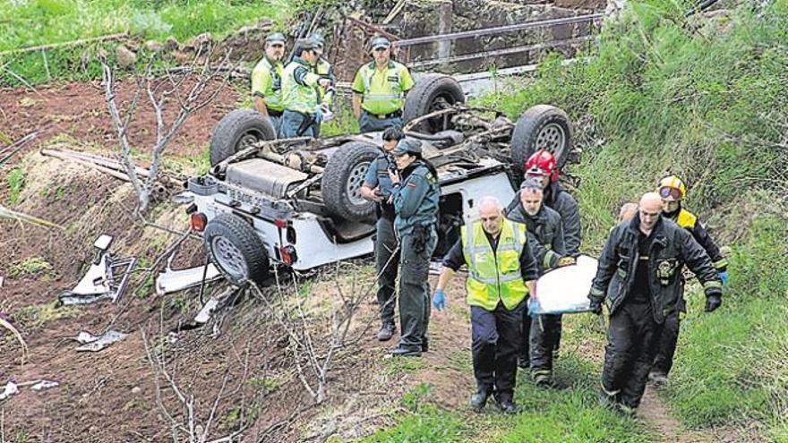 Bomberos del Consorcio y personal de la funeraria trasladan a uno de los fallecidos, ayer, en Montaña Alta, junto a agentes de la Guardia Civil.