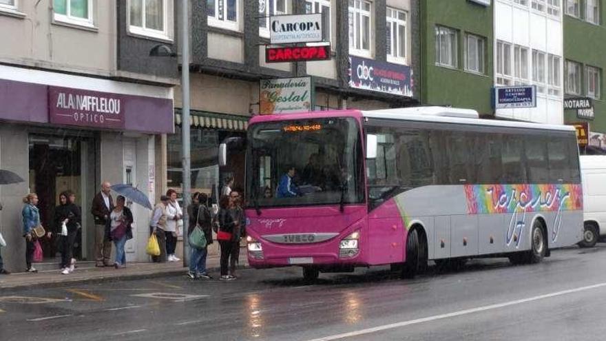 Un autobús recoge varios viajeros en el centro de Arteixo.