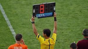 Un cuarto árbitro indica los 8 minutos de tiempo añadido que se aplicarán.