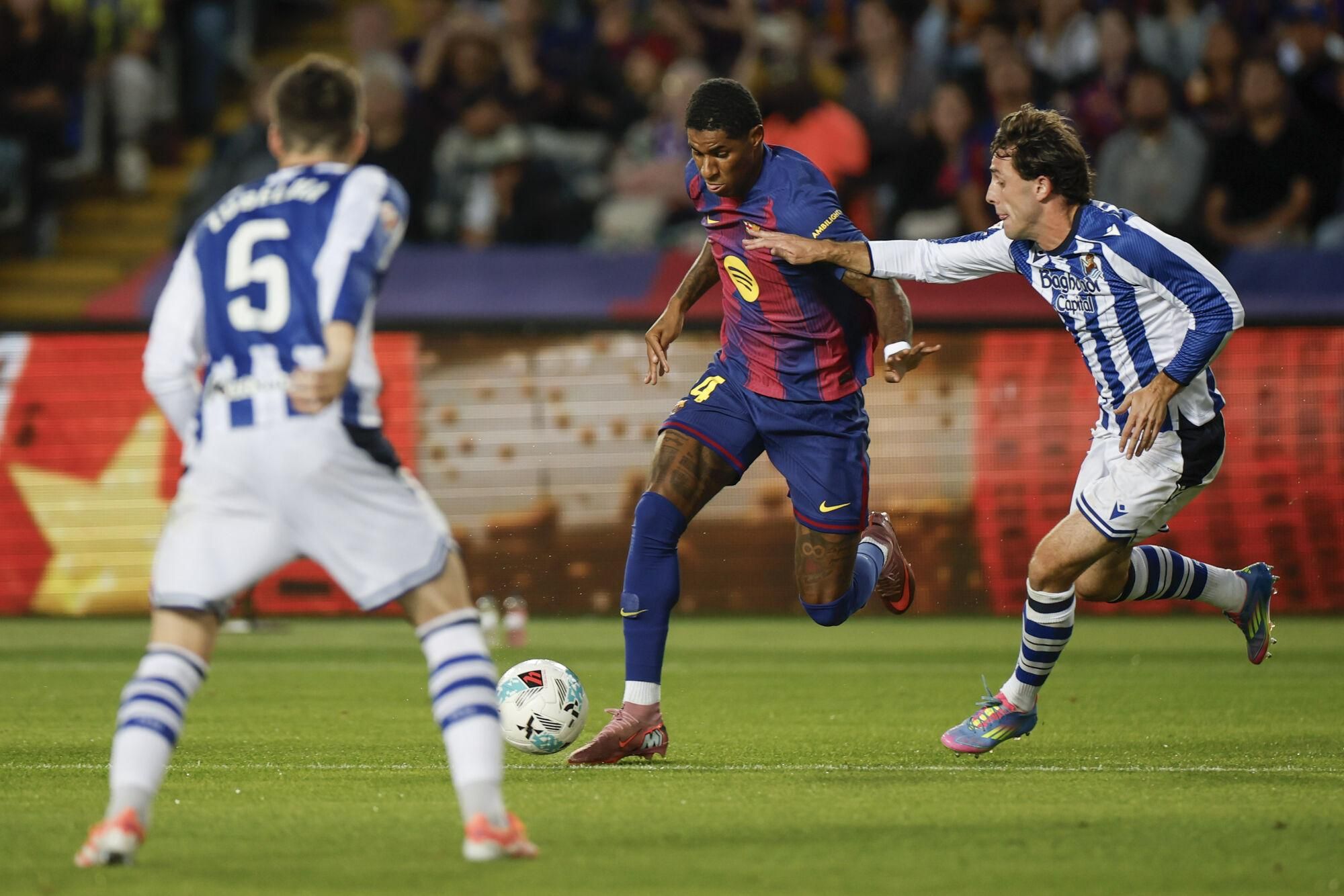 BARCELONA, 28/09/2025.- El delantero británico del FC Barcelona, Marcus Rashford (2d), se lleva el balón ante el defensa de la Real Sociedad, Álvaro Odriozola, durante el encuentro correspondiente a la séptima jornada de Liga EA Sports que FC Barcelona y Real Sociedad disputan este domingo en el estadio de Montjuic, en Barcelona. EFE/Alberto Estevez.