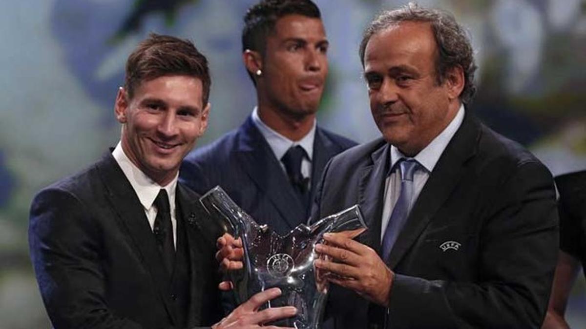 Leo Messi recibe de Michel Platini el premio como Mejor Jugador de la Champions 2014-15 en presencia de Cristiano Ronaldo