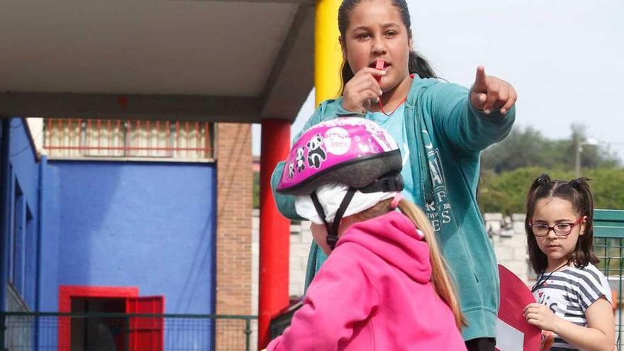 Dos alumnas del colegio Poeta Juan Ochoa, bajo la supervisión de una madre, en el circuito del patio.