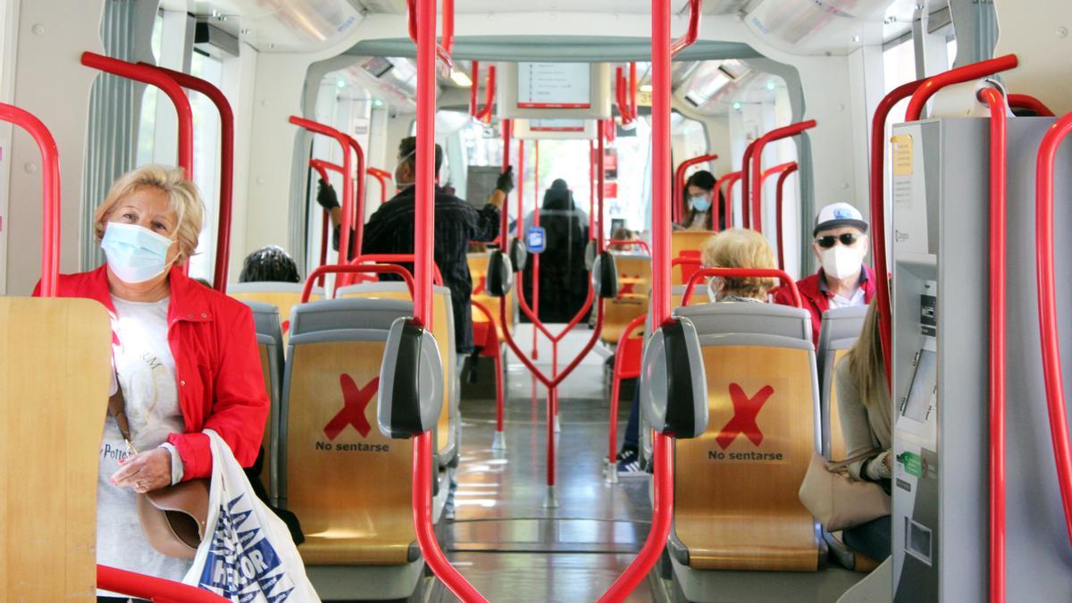 Viajeros en el interior del tranvía de Zaragoza, con mascarillas y distancia de seguridad.