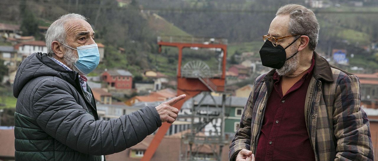 Carlos Vega Zapico y Ernesto Burgos conversan, con el pozo San José al fondo.