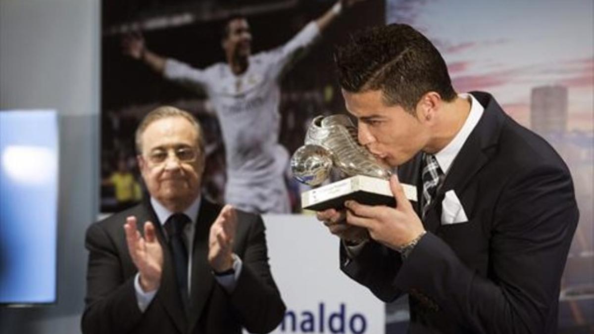 Florentino aplaude el gesto de Ronaldo,, que besa el regalo que besa el trofeo de plata que le regaló el club.