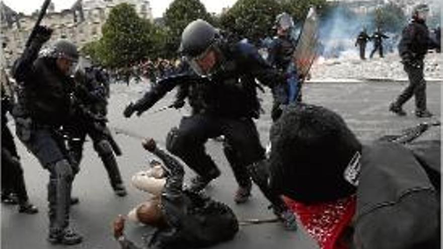 Diversos policies colpegen un manifestant a París.