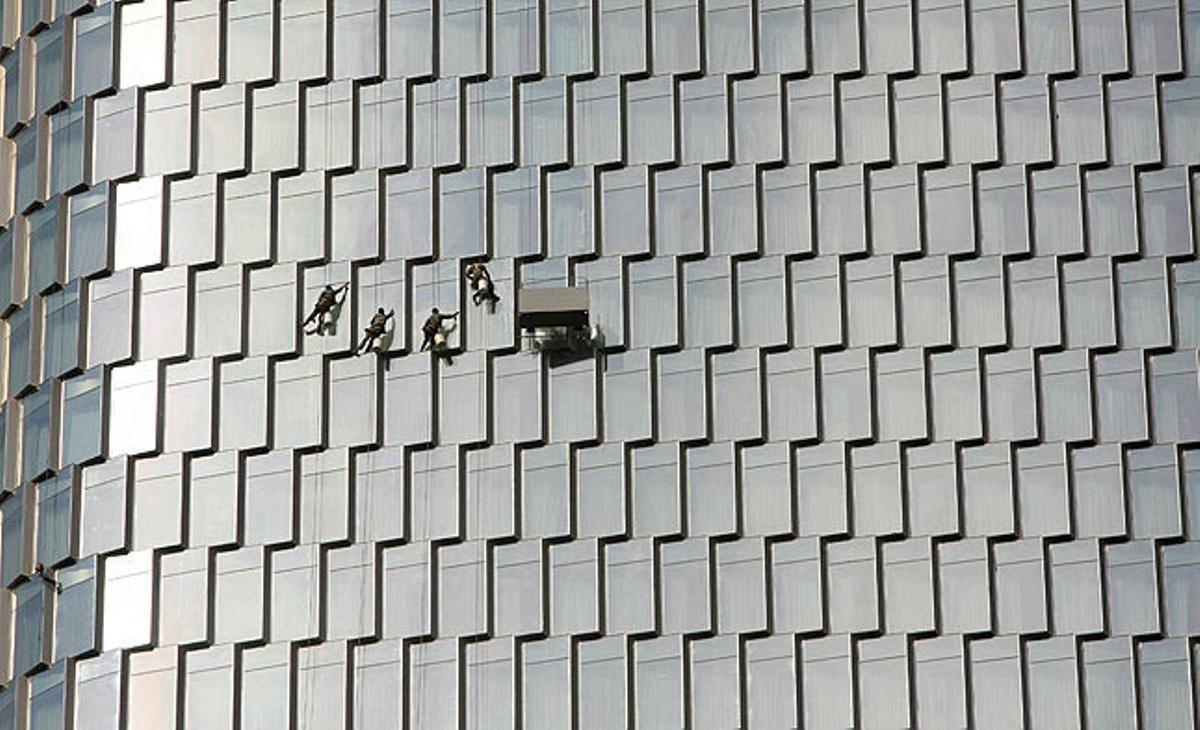 Uns treballadors netegen les finestres de la Torre Zifeng, a la Xina.