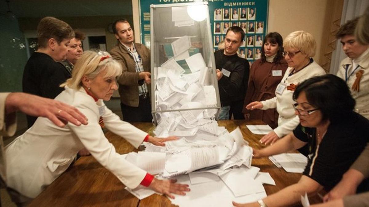 Miembros del comité electoral vacían una urna para hacer el escrutinio tras la votación en Donetsk.