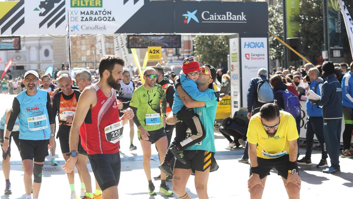 Un participante besa a su hijo tras la línea de meta de la XV edición de la Maratón de Zaragoza.