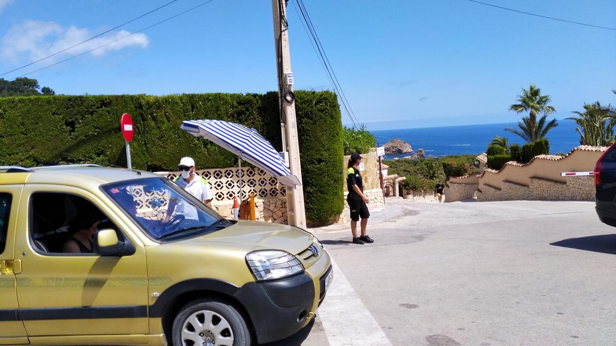 Los controladores de la cala de la Barraca le indican a unos turistas que la cala está cerrada al tener el aforo completo