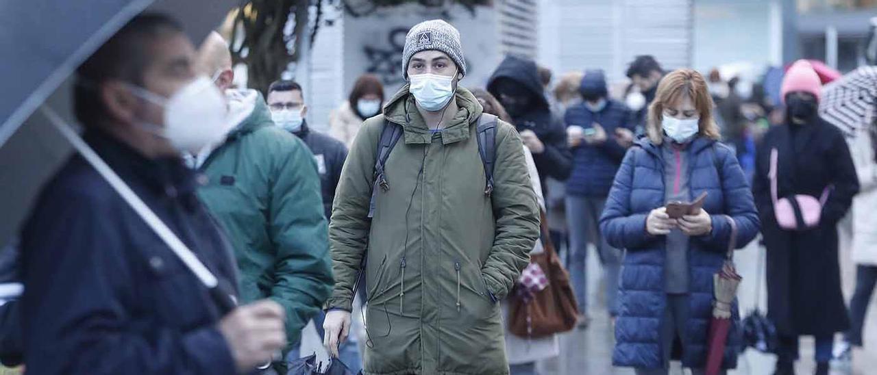 Varias personas esperan en la cola para someterse a una PCR gratuita en una calle de Vigo