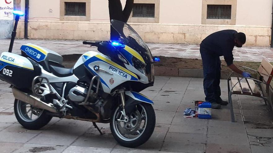 Un operario repintando uno de los bancos que aparecieron esta mañana con los colores de la bandera arcoíris.