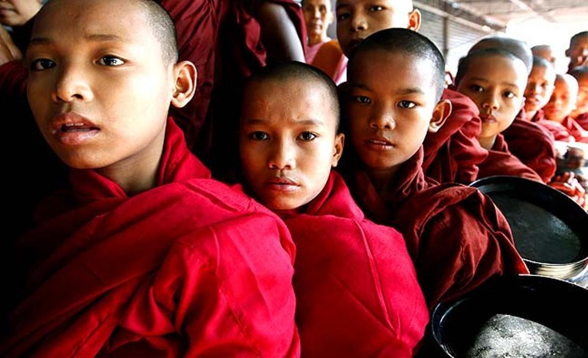 Joves monjos budistes fan cua per demanar almoina al davant de la Lliga Nacional per a la Democràcia (LND), la seu del partit a Yangon (Myanmar).
