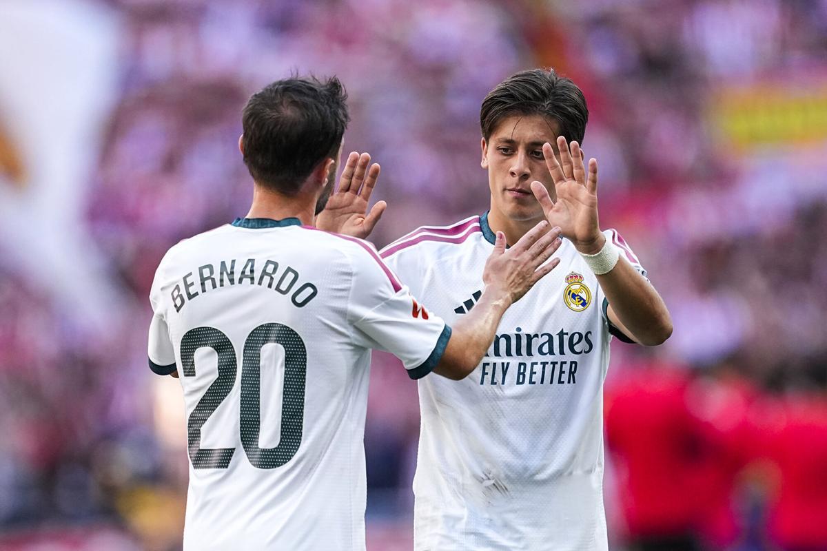 Bernardo Silva y Arda Güler, jugadores del Real Madrid, se saludan en un cambio.