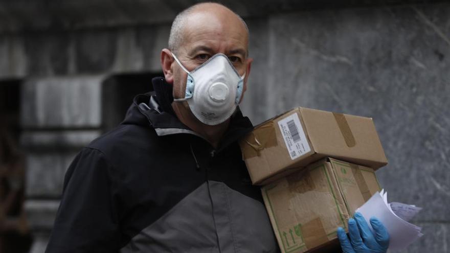 Un repartidor con mascarilla y guantes trabaja en Bilbao.