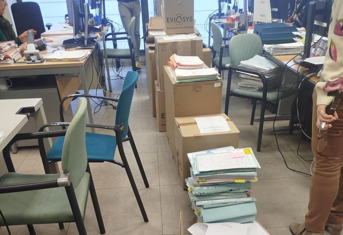 Expedientes acumulados en el suelo en la oficina judicial.