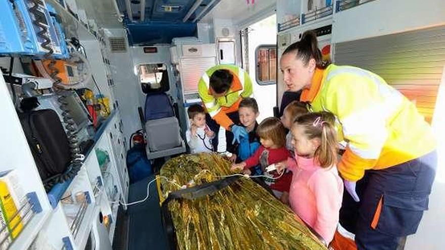 Varios niños, en el interior de la uvi móvil, junto a los sanitarios.