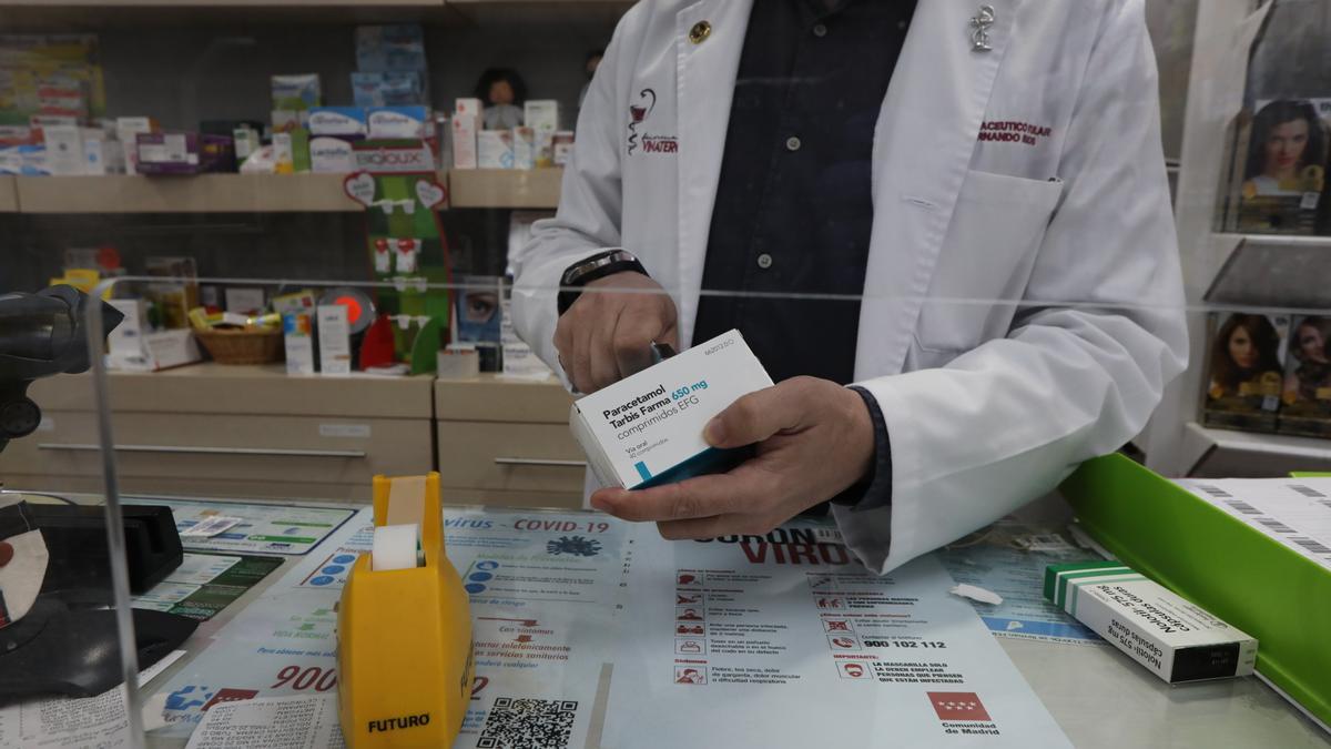 Un farmacéutico recorta el código de barras de una caja de paracetamol en su farmacia de Madrid.