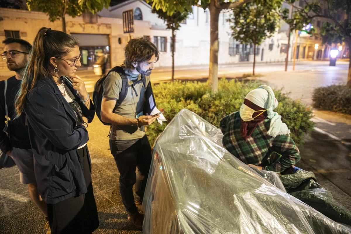 Voluntaris parlen amb una dona sense llar al costat de l’Estació Jove de Girona, en una imatge d’arxiu.