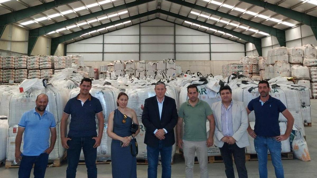 Autoridades y representantes de la empresa, en la nave de almacenaje de semillas.