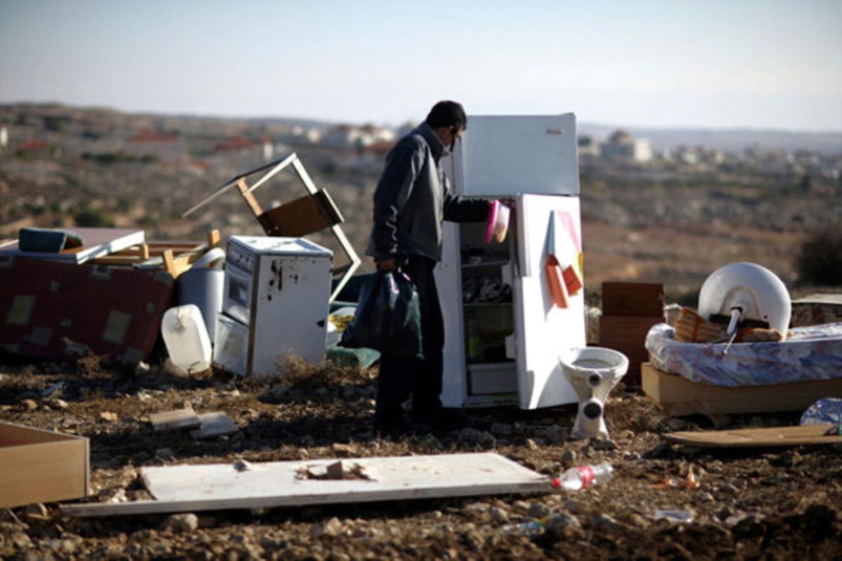 Un colon israelià intenta rescatar alguna de les seves pertinences després que les forces de seguretat israelianes demolissin tres immobles il·legals a Oz Zion, a prop de Ramal·la (Cisjordània).
