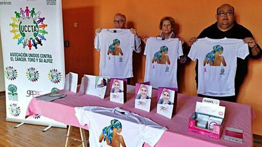 Responsables de la asociación muestran las camisetas creadas por el Día Mundial del Cáncer de Mama.