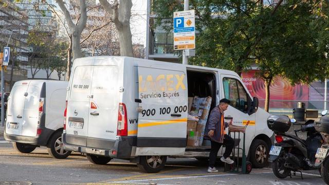 Un repartidor de paqueteria baixa enviaments de la seva furgoneta al barri del Poble Nou de Barcelona.