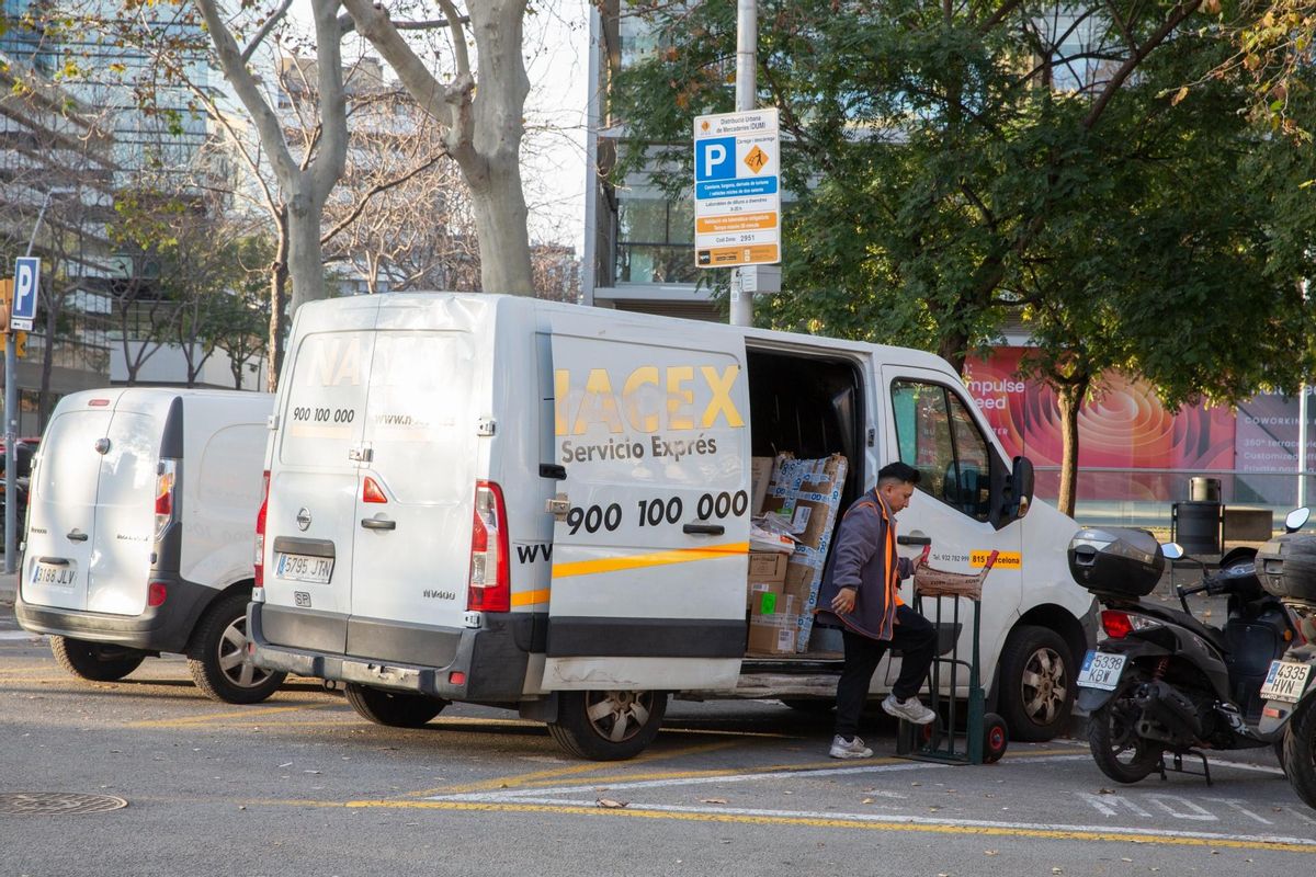 Un repartidor de paquetería baja envíos de su furgoneta en el barrio de Poble Nou de Barcelona. Un repartidor de paquetería baja envíos de su furgoneta en el barrio de Poble Nou de Barcelona.