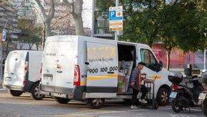 Un repartidor de paquetería baja envíos de su furgoneta en el barrio de Poble Nou de Barcelona. Un repartidor de paquetería baja envíos de su furgoneta en el barrio de Poble Nou de Barcelona.