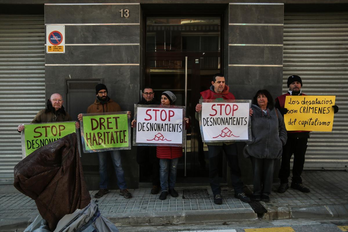 UNA COMITIVA DE LA PAH PROTESTA AMB PANCARTES DAVANT L'HABITATGE.