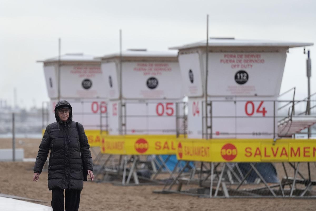 Vecinos de Barcelona pasean bajo la lluvia en la playa de la Barceloneta durante el temporal, a 19 de enero de 2026, en Barcelona, Cataluña (España).