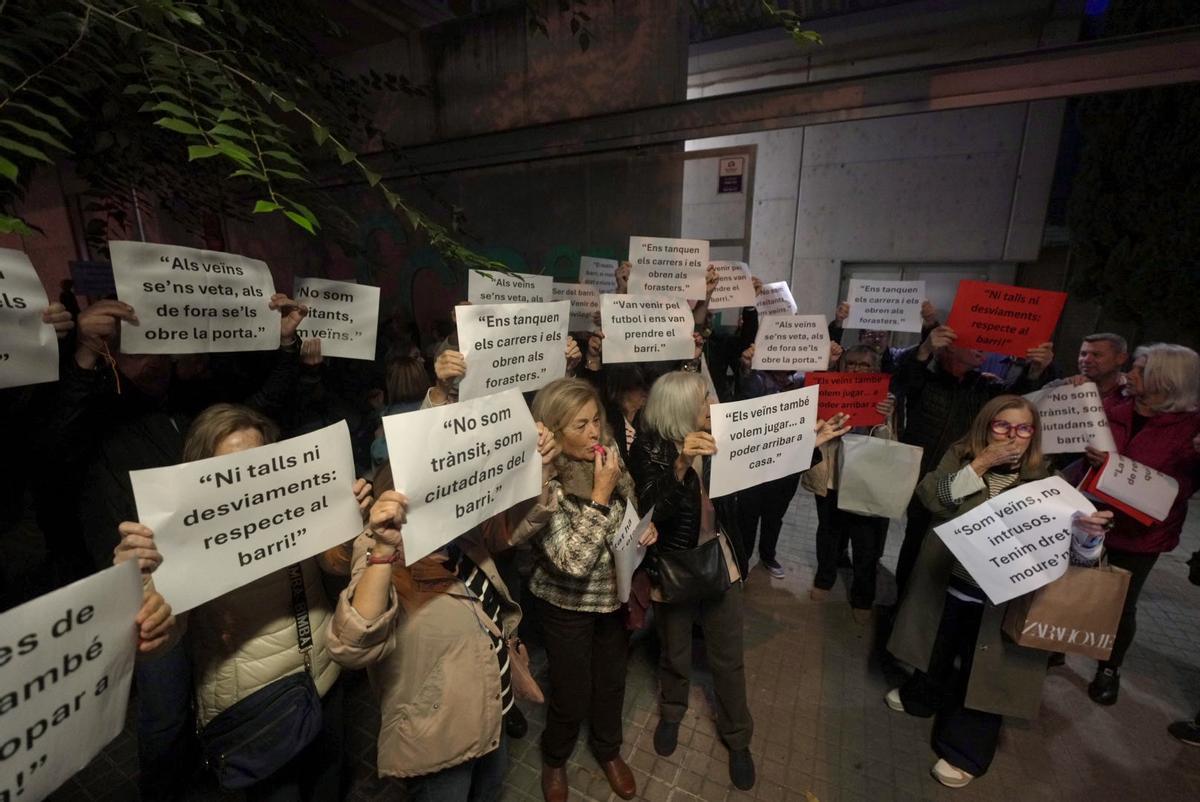 Vecinos de Sant Ramon muestran carteles críticos con el plan de movilidad de retorno al Camp Nou, en Barcelona.