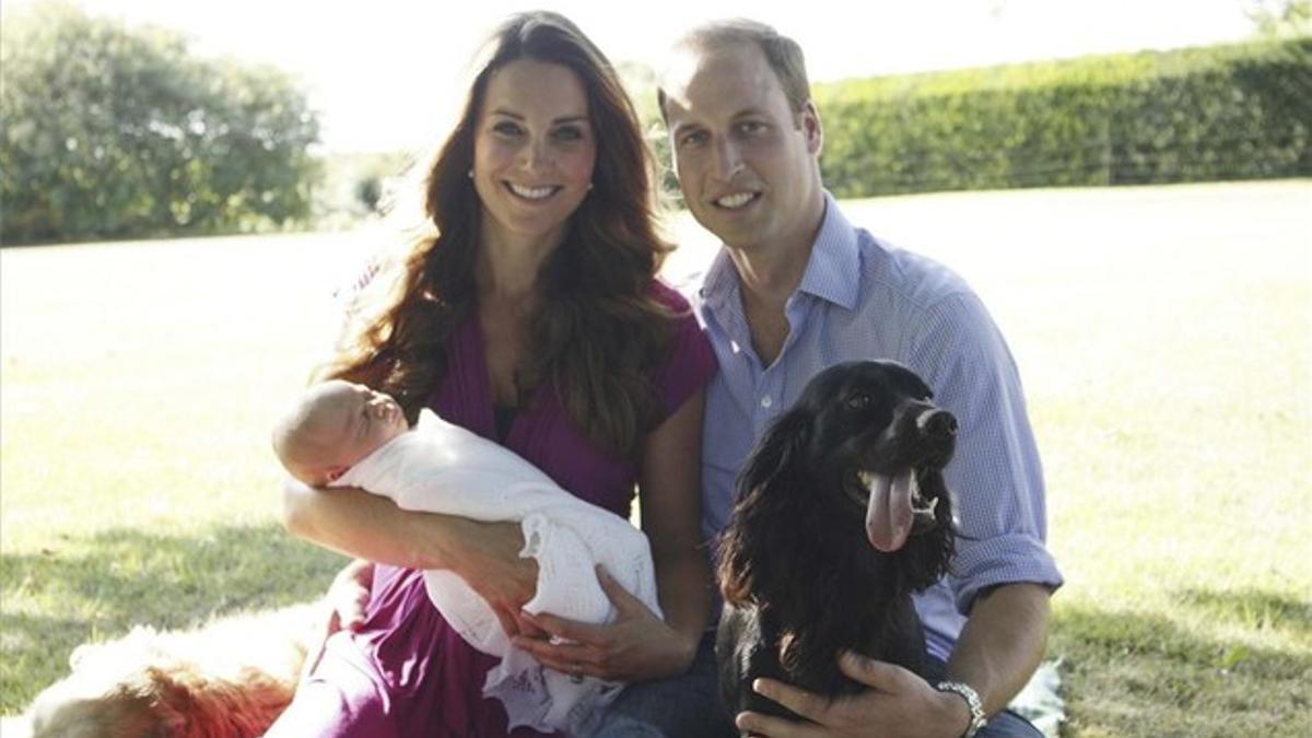 Kate, con el principe Jorge en brazos, el príncipe Guillermo, el cocker 'Lupo' y, acostado detras, 'Tilly', el golden retriever de la familia Middleton