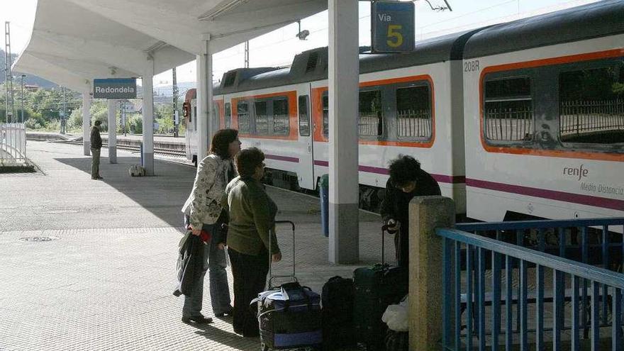 Viajeros en la estación de trenes de Redondela.  // De Arcos