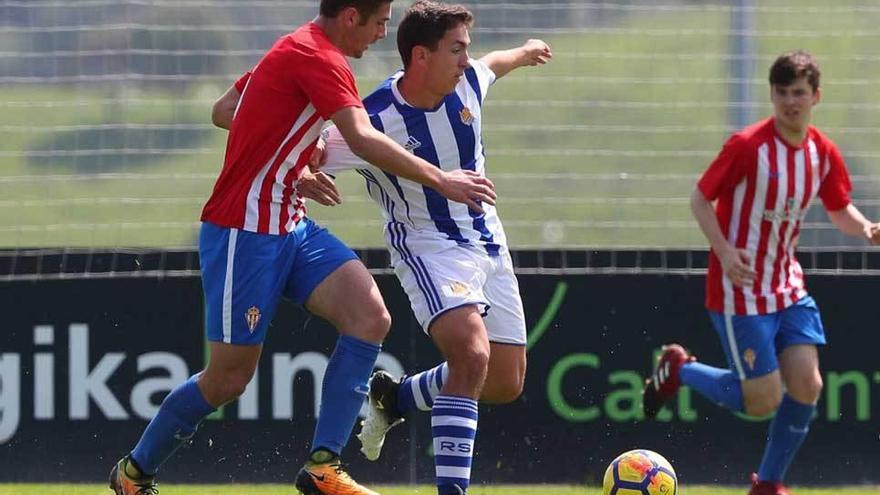 José Gragera pugna con un futbolista donostiarra, con Guille Rosas al fondo.