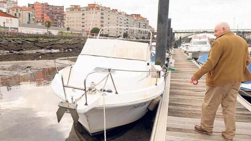 Un usuario del Club Naval en los pantalanes del puerto deportivo con la marea baja.