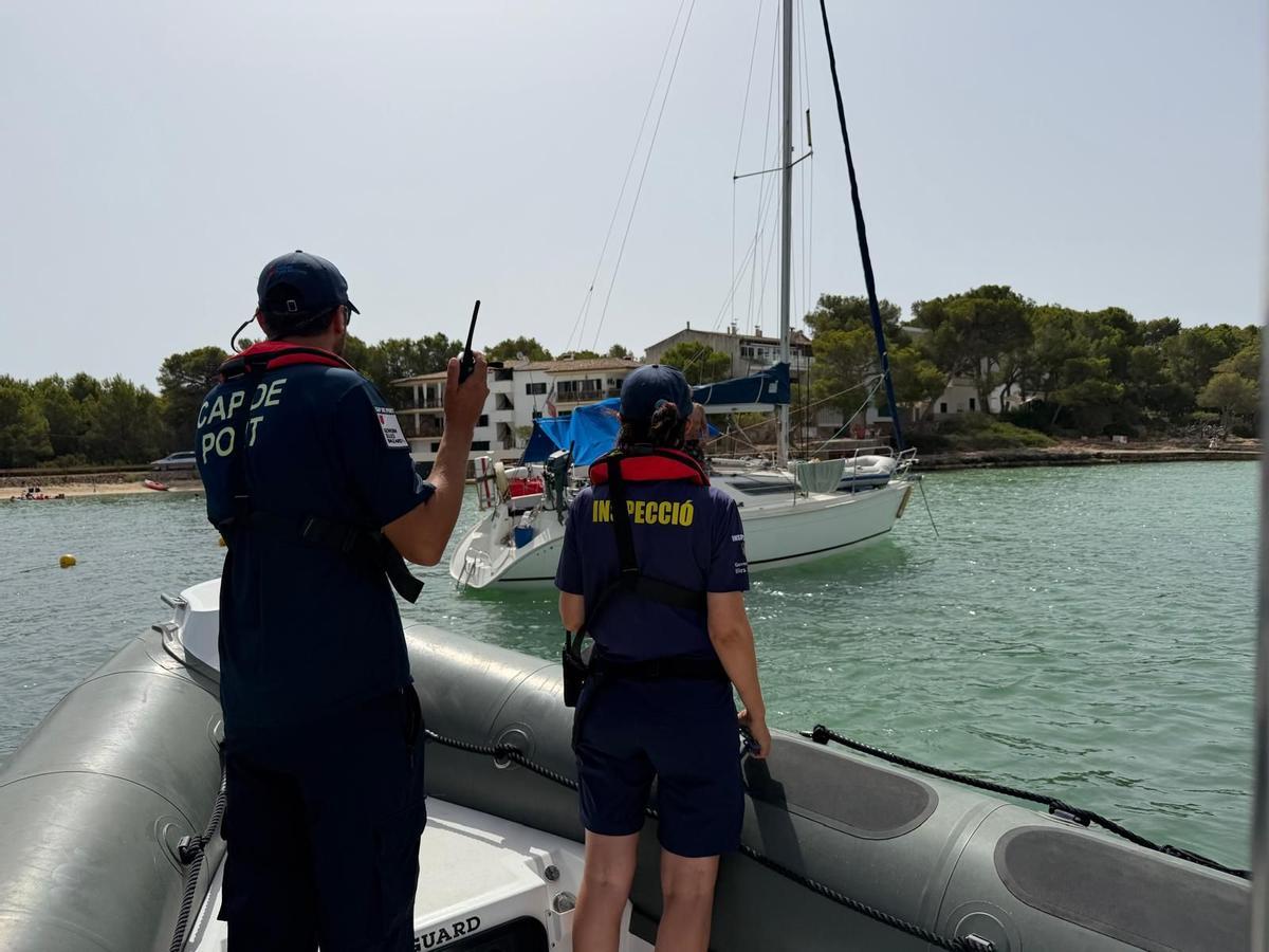 Dos vigilantes se aproximan a un velero fondeado en Portocolom.