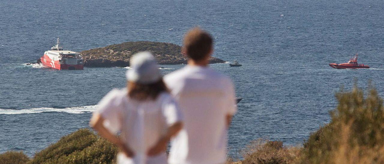 Una pareja observa el ferry encallado en el islote de es Malví Pla.