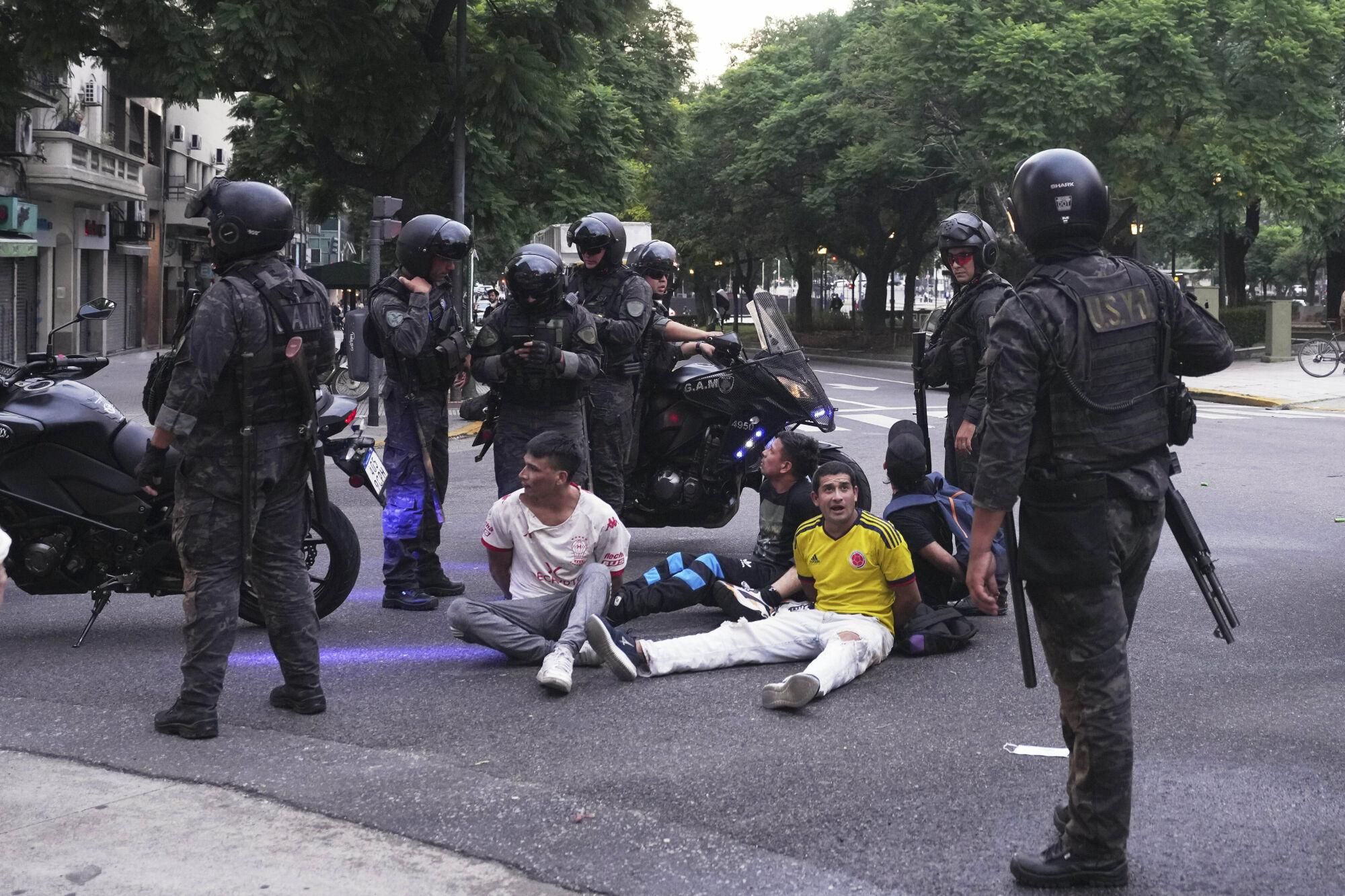 Police detain protesters during a demonstration by soccer fans and retirees demanding higher pensions and opposing austerity measures imposed by Javier Milei's government, in Buenos Aires, Argentina, Wednesday, March 12, 2025. (AP Photo/Natacha Pisarenko). EDITORIAL USE ONLY/ONLY ITALY AND SPAIN